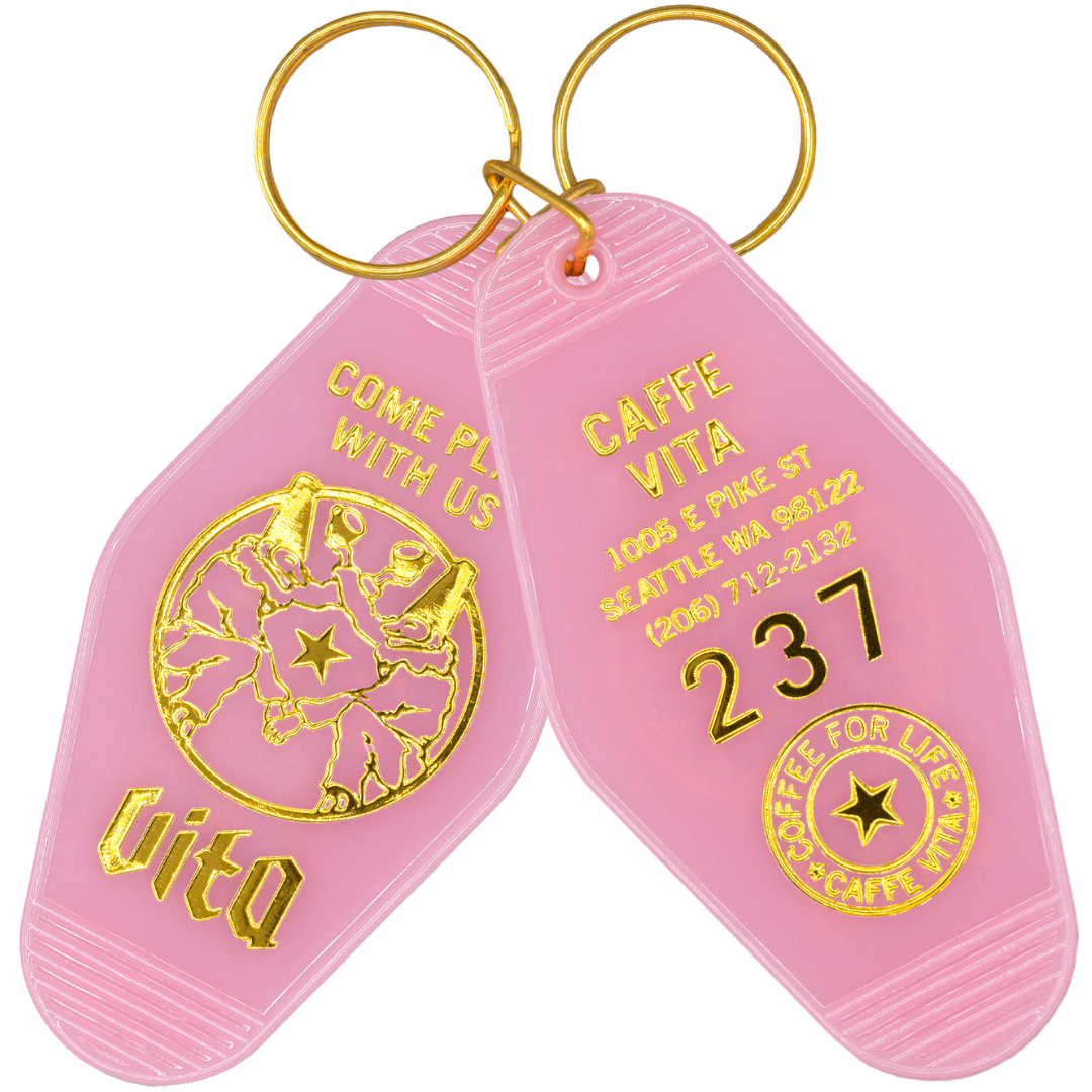 Pink (front and back) keychain reads "Come play with us" featuring Seattle address and logos. No background