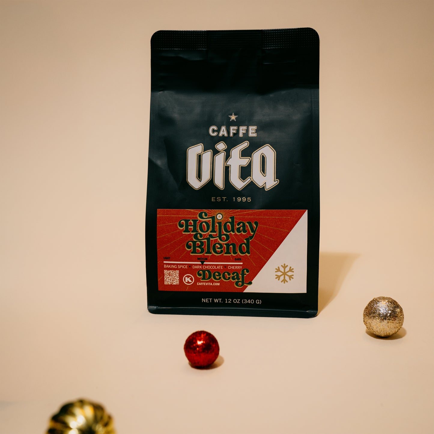 12oz bag of Holiday Decaf with ornaments scattered in foreground. 