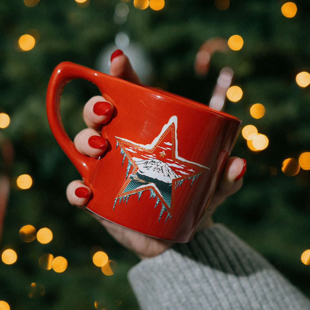 Holiday Mountain Mug - back design held in front of Christmas tree